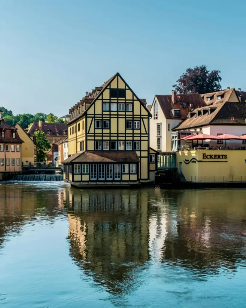 Fachwerkhäuser am Fluss in Bamberg mit Spiegelung im Wasser und historischer Altstadt