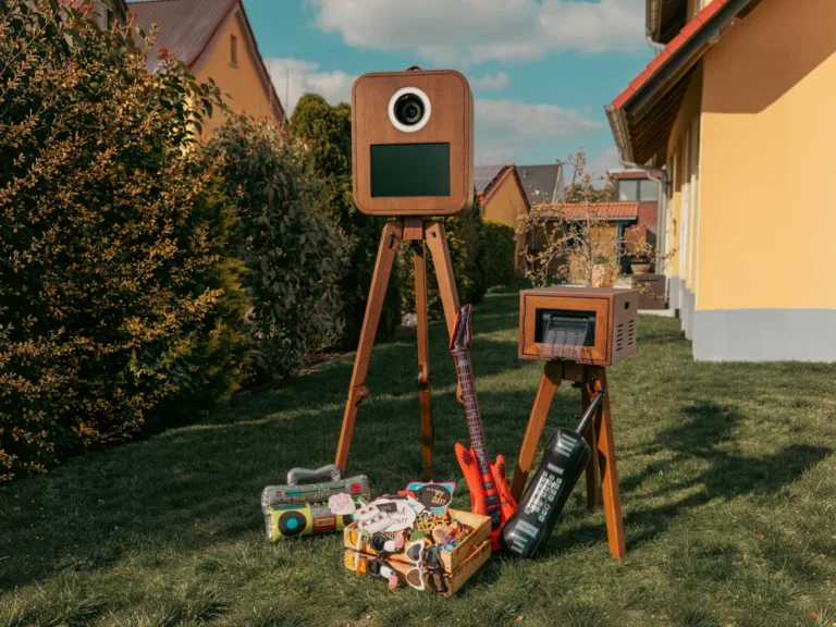 Fotobox und Drucker im Holzdesign mit Requisiten im Garten.